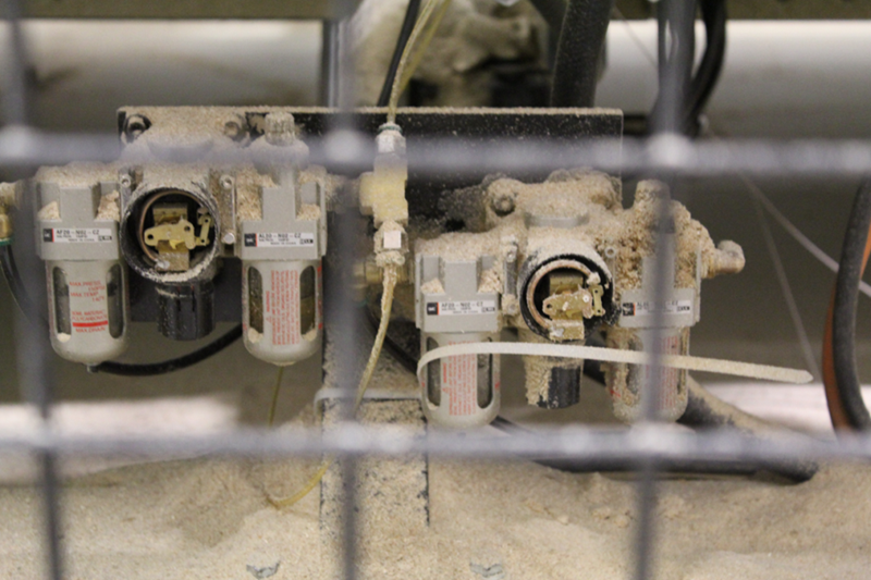 Cette photo représente des F.R.L. (filtre, régulateur, lubrificateur) dont les manomètres des régulateurs sont hors d’usage. La partie "Régulateur" permet d’ajuster précisément les pressions pneumatiques d’alimentation des différentes composantes de l’équipement. 